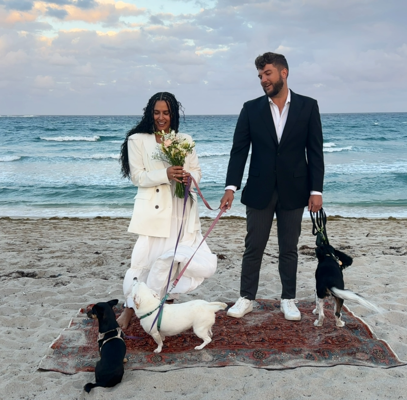 Rachel on the beach with her husband, dogs, and a vintage rug